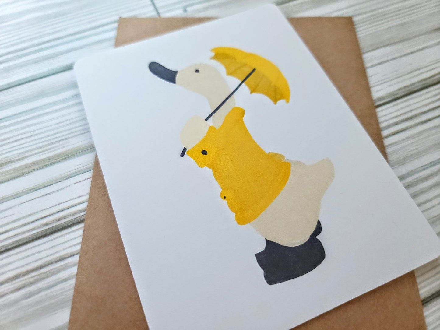 Duck in a Yellow Rainjacket with Umbrella Handmade Greeting Card - Recycled Paper and Kraft Envelope - Angled Overhead Shot