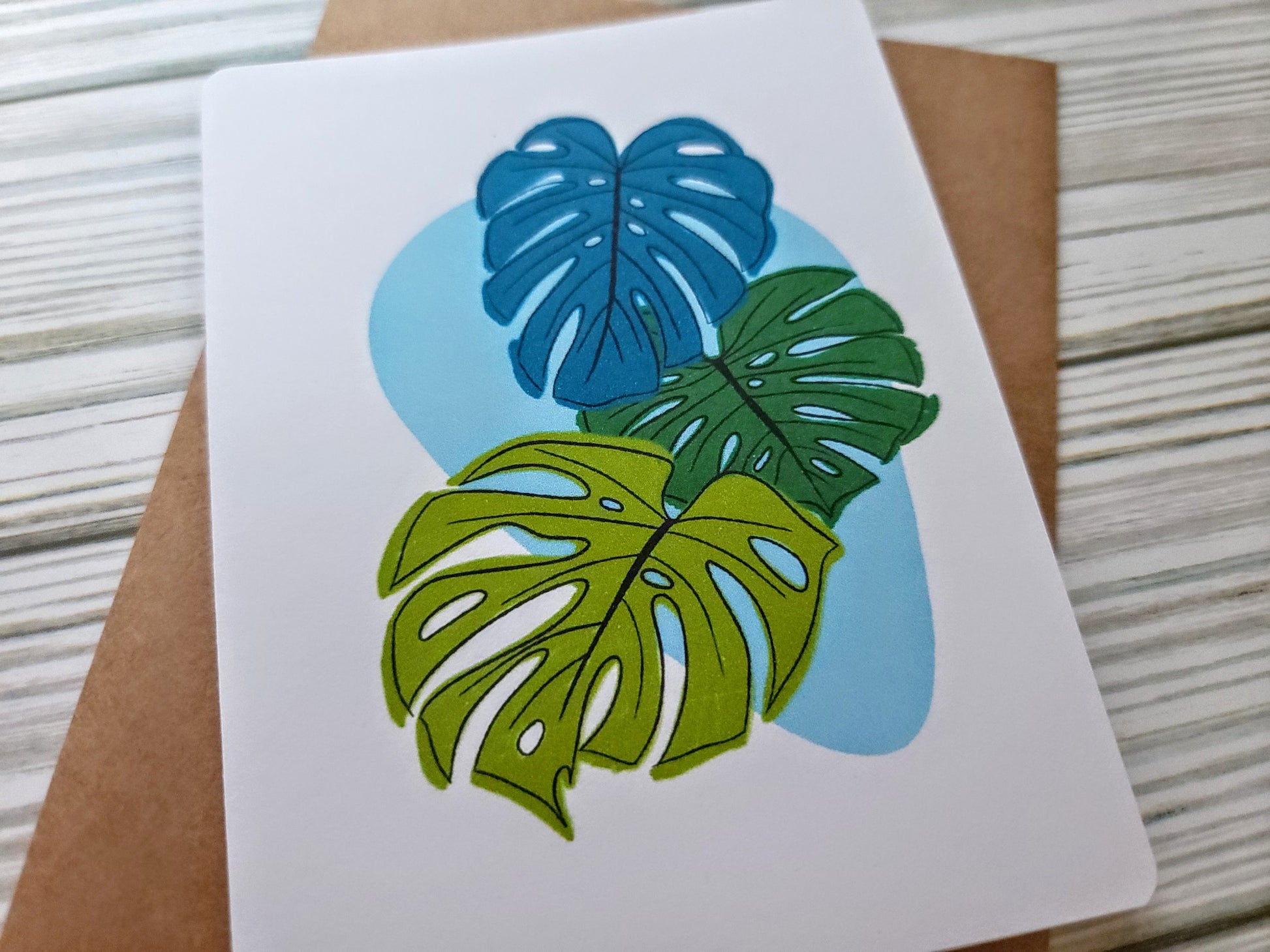 Monstera Leaves Handmade Greeting Card - Recycled Paper and Kraft Envelope - Angled Overhead Shot
