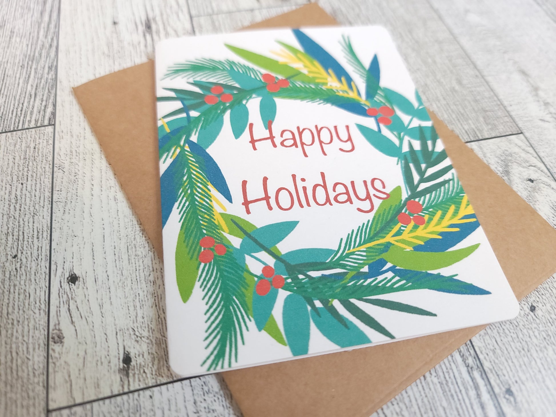 Happy Holidays Wreath Handmade Greeting Card - Recycled Paper and Kraft Envelop - Angled Overhead Shot